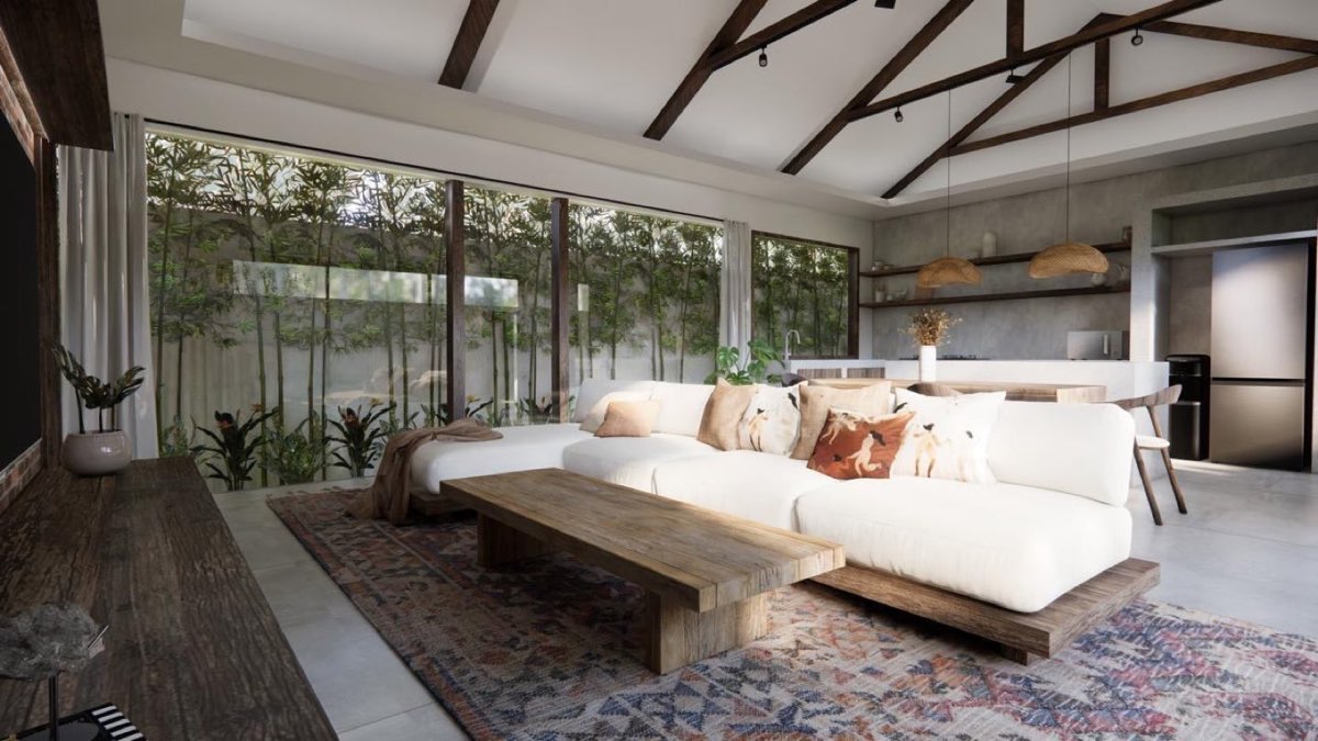 Living room with white sectional sofa and kilim rug under an exposed timber truss, glazed to a bamboo screen