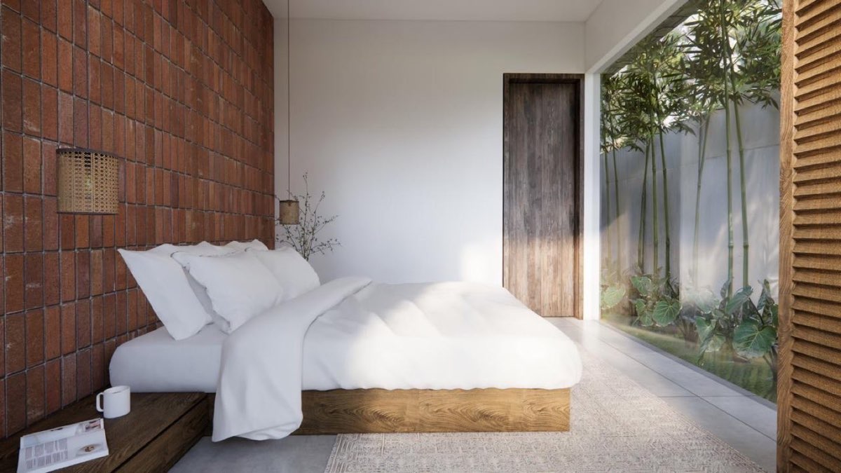 Bedroom with brick wall, low timber bed and a louvred timber screen filtering light from the garden