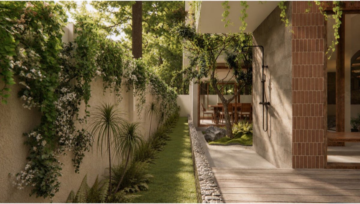 Side garden with jasmine spilling over a lime-plaster wall and an outdoor shower on a fired-brick column
