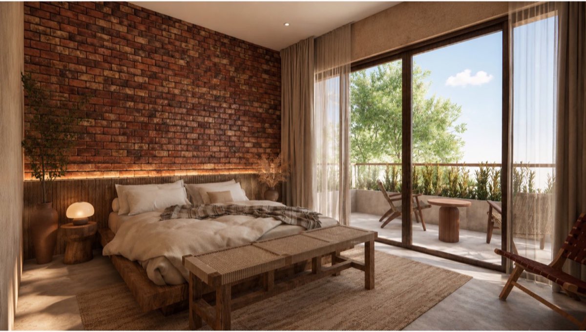 Bedroom with a reclaimed brick feature wall and sliding glazing opening onto a planted terrace